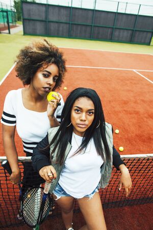 young pretty girlfriends hanging on tennis court, fashion stylish dressed swag, best friends happy...