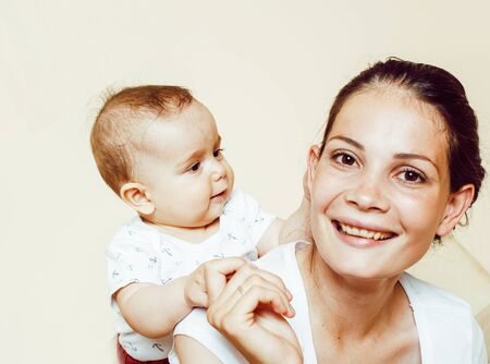 young brunette happy mother holding toddler baby son, breast-feeding concept, people lifestyleの写真素材