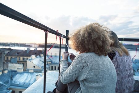 two teenagers girl friends having fun on roof top, liestyle people traveling europe conceptの写真素材