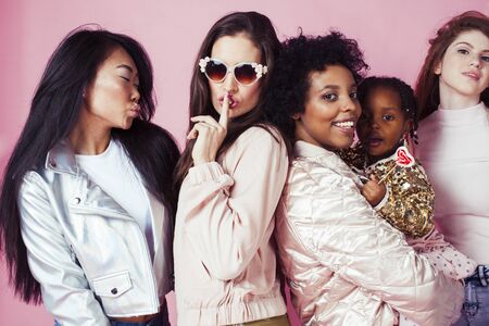 three different nation girls with diversuty in skin, hair. Asian, scandinavian, african american cheerful emotional posing on pink background, woman day celebration, lifestyle people conceptの写真素材