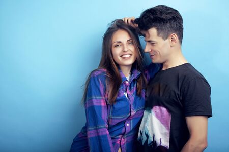 happy couple together posing cheerful on blue background , guy and girl students together friends