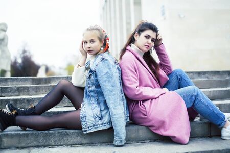 young happy students teenagers at university building on stairs, lifestyle people concept brunette and blond girlの写真素材