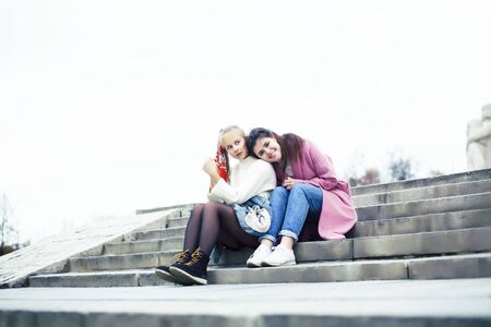 young happy students teenagers at university building on stairs, lifestyle people concept brunette and blond girlの写真素材