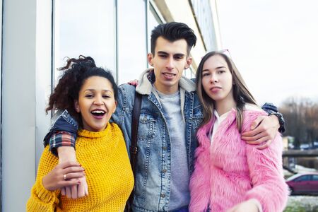 cute group of teenages at the building of university with books huggings, diversity nations real students lifestyleの写真素材