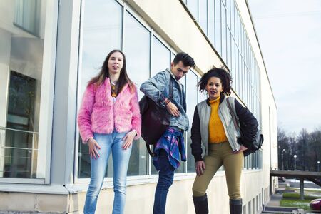 cute group of teenages at the building of university with books huggings, diversity nations real students lifestyleの写真素材