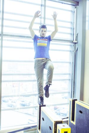 young handsome man doing parkour in gym inside, lifestyle sport people concept
