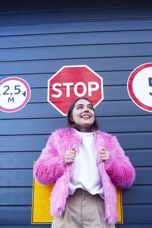 young cute girl teenager gesturing hanging around city parking and teasing with stop sign, lifestyle...