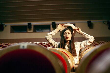 portrait of a pretty girl hipster in a movie theater posing in fashion style, dreaming aloneの写真素材