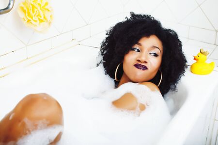 young pretty african american girl taking bath with foam happy smiling, lifestyle people conceptの写真素材