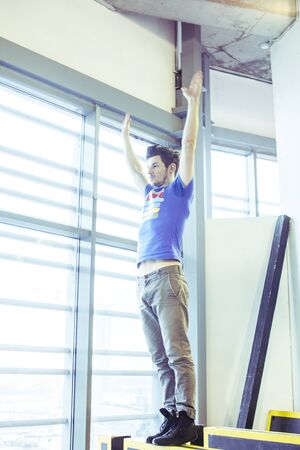 young handsome man doing parkour in gym inside, lifestyle sport people concept