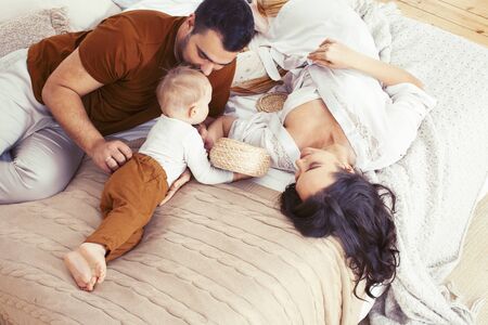 young happy family together having fun in bed, lifestyle people concept closeupの写真素材