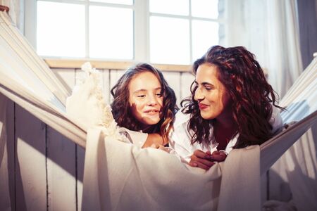 young pretty sisters at home early morning in hammock, lifestyle casual people conceptの写真素材