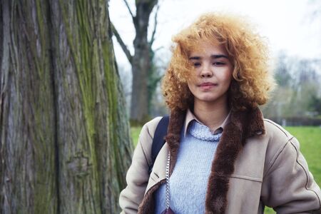 young cute blond african american girl student smiling in green park, lifestyle people conceptの写真素材