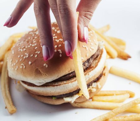 woman hand with manicure holding big burger french fries on background, people eating food concept closeupの写真素材