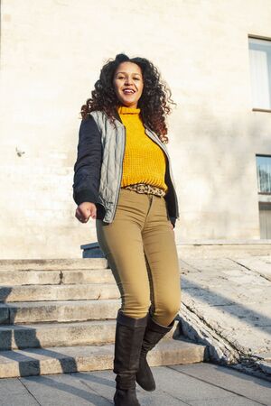 young pretty afican american girl happy smiling on city background, lifestyle people outsideの写真素材