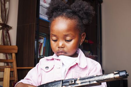 little cute african american girl playing with animal toys at home, pretty adorable princess in interior happy smiling, lifestyle people conceptの写真素材