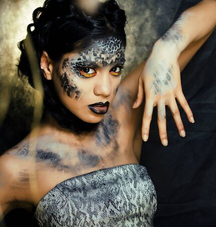 fashion portrait of pretty young woman with creative make up like a snake, halloween conceptの写真素材