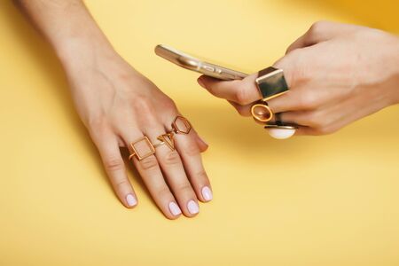 womans hand taking picture of her new manicure with fashion jewellery on her phone, girls stuff concept close upの写真素材