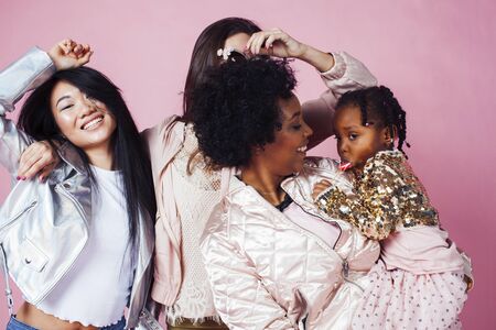 different nation girls with diversuty in skin, hair. Asian, scandinavian, african american cheerful emotional posing on pink background, woman day celebration, lifestyle people conceptの写真素材