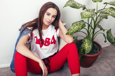 young pretty teenage hipster girl posing emotional happy smiling on white background, lifestyle...