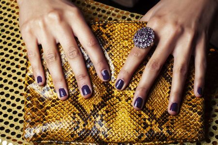pretty fingers of african american woman holding money close up with purse, luxury jewellery on python clutch, cash for giftsの写真素材