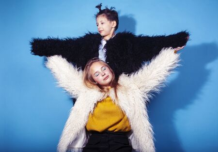 young and pretty fashion models boy and teenage girl posing cheerful on blue background, lifestyle...