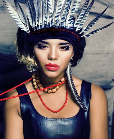 young pretty woman with make up like red indian, futher in hair, fashion hallowen conceptの写真素材