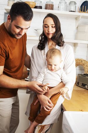 young family with little cute son on kitchen in morning happy smiling, lifestyle people concept