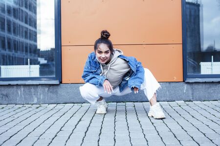 young pretty teenage girl posing cheerful happy smiling wearing street style outside in europe city,...