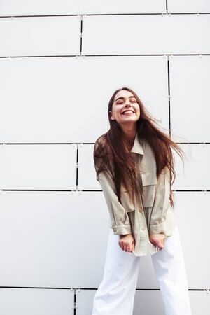 young pretty teenage girl posing cheerful happy smiling wearing street style outside in europe city, lifestyle people conceptの写真素材