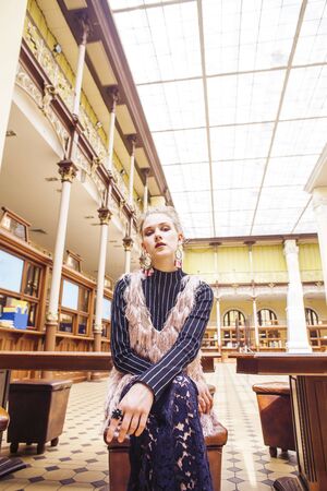 young pretty blond girl posing in fashion style at vintage europe hall interior, lifestyle rich...
