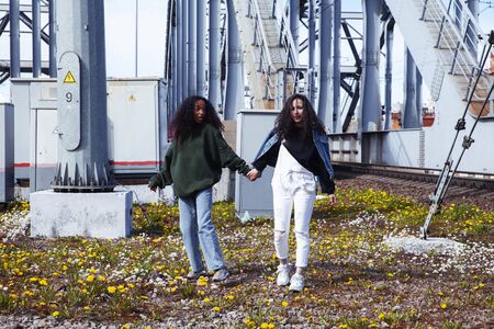 young cute teenage girls together in industrial zone happy smiling having fun, big city lifestyle fashion peopleの写真素材