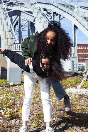 young cute teenage girls together in industrial zone happy smiling having fun, big city lifestyle...