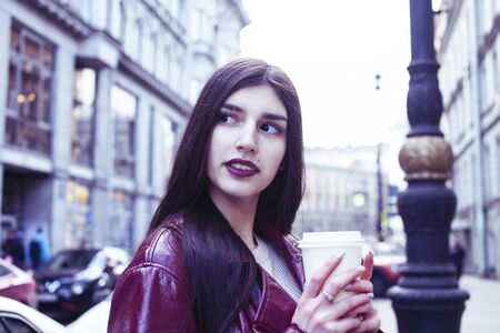 young pretty girl outside in city street with coffee happy smiling, lifestyle fashion peopple...