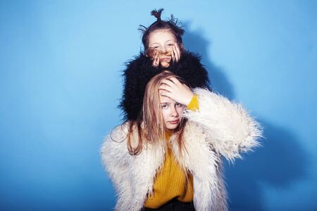 young and pretty fashion models boy and teenage girl posing cheerful on blue background, lifestyle...