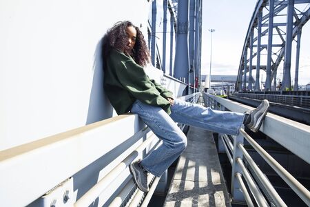 young cute teenage african girl in industrial zone happy smiling having fun, big city lifestyle fashion peopleの写真素材