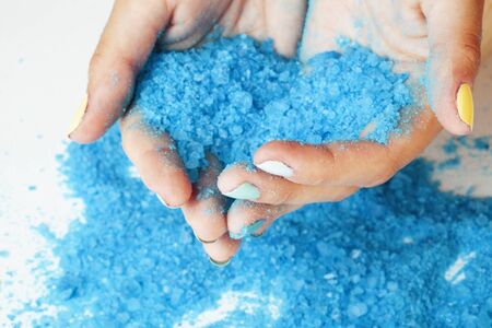 woman hands holding sea shell and sea salt with manicured nails closeupの写真素材