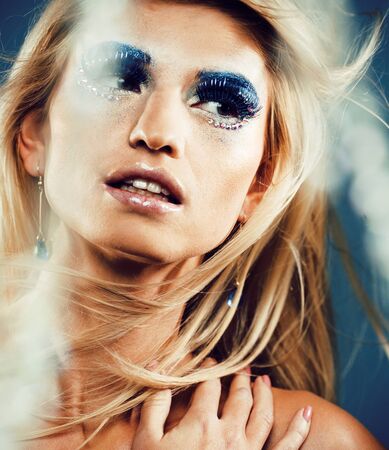 beauty young snow queen in fairy flashes with hair crown on her head close up in cold blue lightの写真素材
