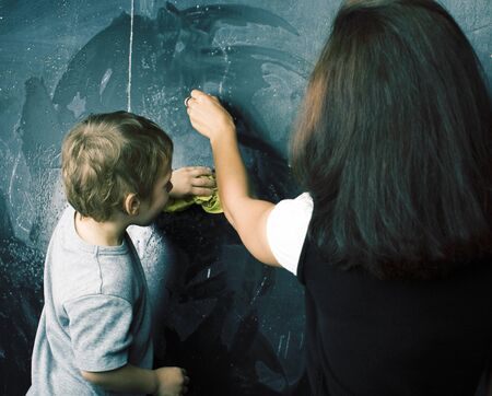 little cute boy in glasses with young real teacher, classroom studying at blackboard school kidoの写真素材