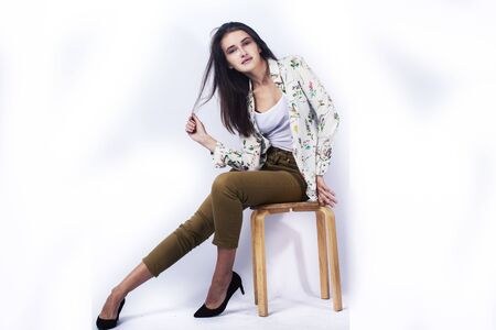 young pretty brunette girl hipster posing frendly against white background wall, smiling woman with...