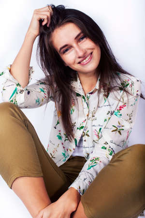 young pretty brunette girl hipster posing frendly against white background wall, smiling woman with long hairの写真素材