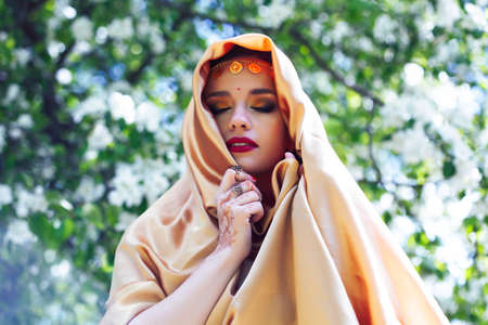 young pretty indian girl in jewelry and veil posing cheerful happy smiling in green park, lifestyle people conceptの写真素材