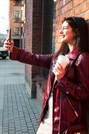 young pretty girl outside in city street with coffee happy smiling, lifestyle fashion peopple...