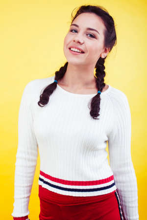 lifestyle people concept: pretty young school teenage girl having fun happy smiling on yellow backgroundの写真素材