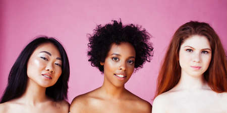 different nation girls with diversuty in skin, hair. Asian, scandinavian, african american cheerful emotional posing on pink background, woman day celebration, lifestyle people conceptの写真素材