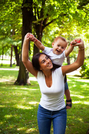 young pretty brunette mother with little cute boy walking in park happy smiling, lifestyle people conceptの写真素材