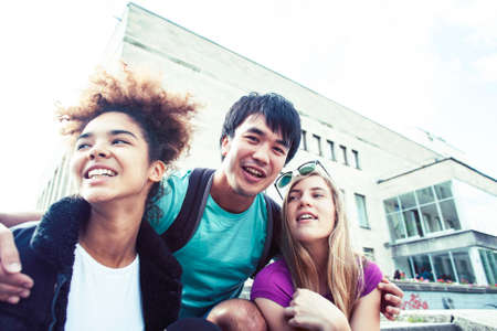 cute group of teenages at the building of university with books huggings, diversity nations, having lunchの写真素材