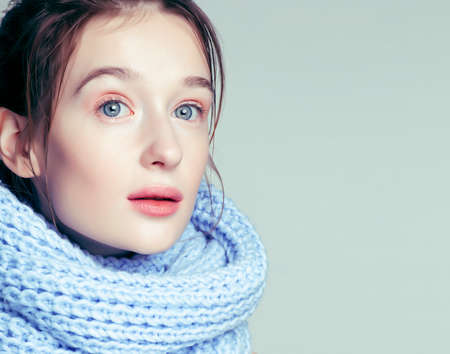 beauty young blond woman in scarf with weathered lips close up isolated, dehydrated winter skin cosmetic conceptの写真素材