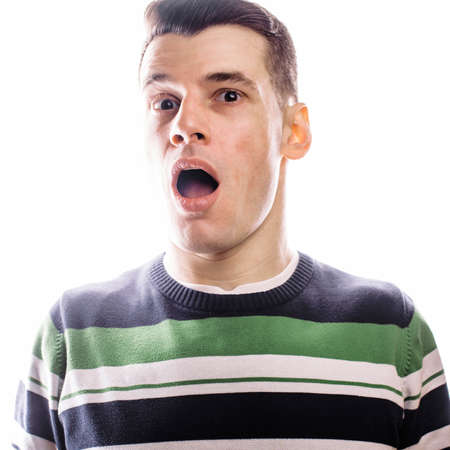 Portrait of a smart serious young man standing against white background. Emotional concept for...