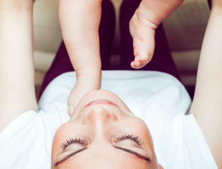 young brunette happy mother holding toddler baby son, breast-feeding concept, people lifestyleの写真素材
